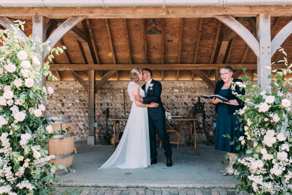 A couple embrace during their Rathfinney Wine Estate wedding between two lush white flower columns